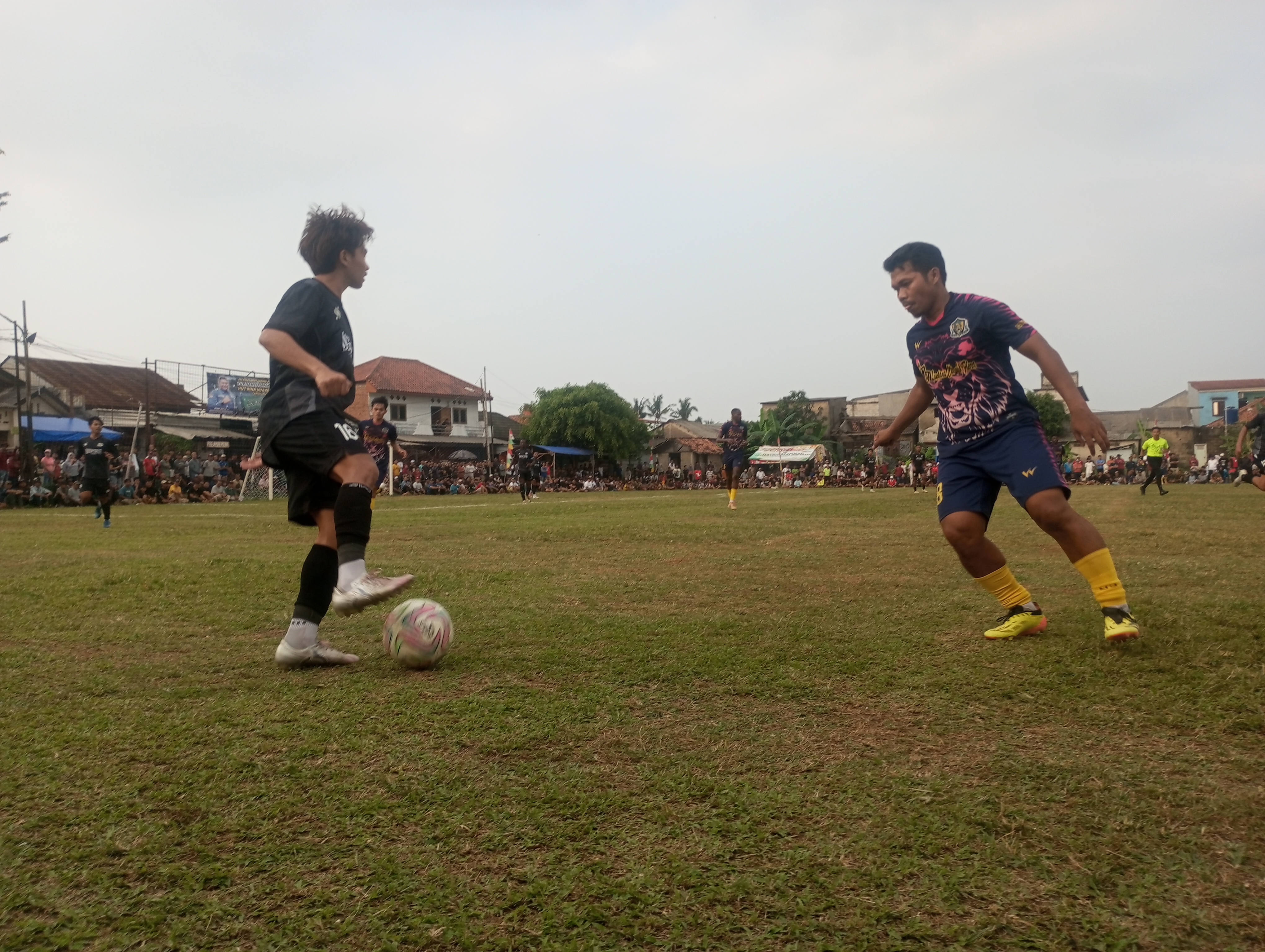 Bek kiri Denis FC, Idris Afandi (kanan) mencoba menghentikan pergerakan penyerang Dispora FC, Ahong pada laga Minggu (29/06/2026).(tangselpos.id).