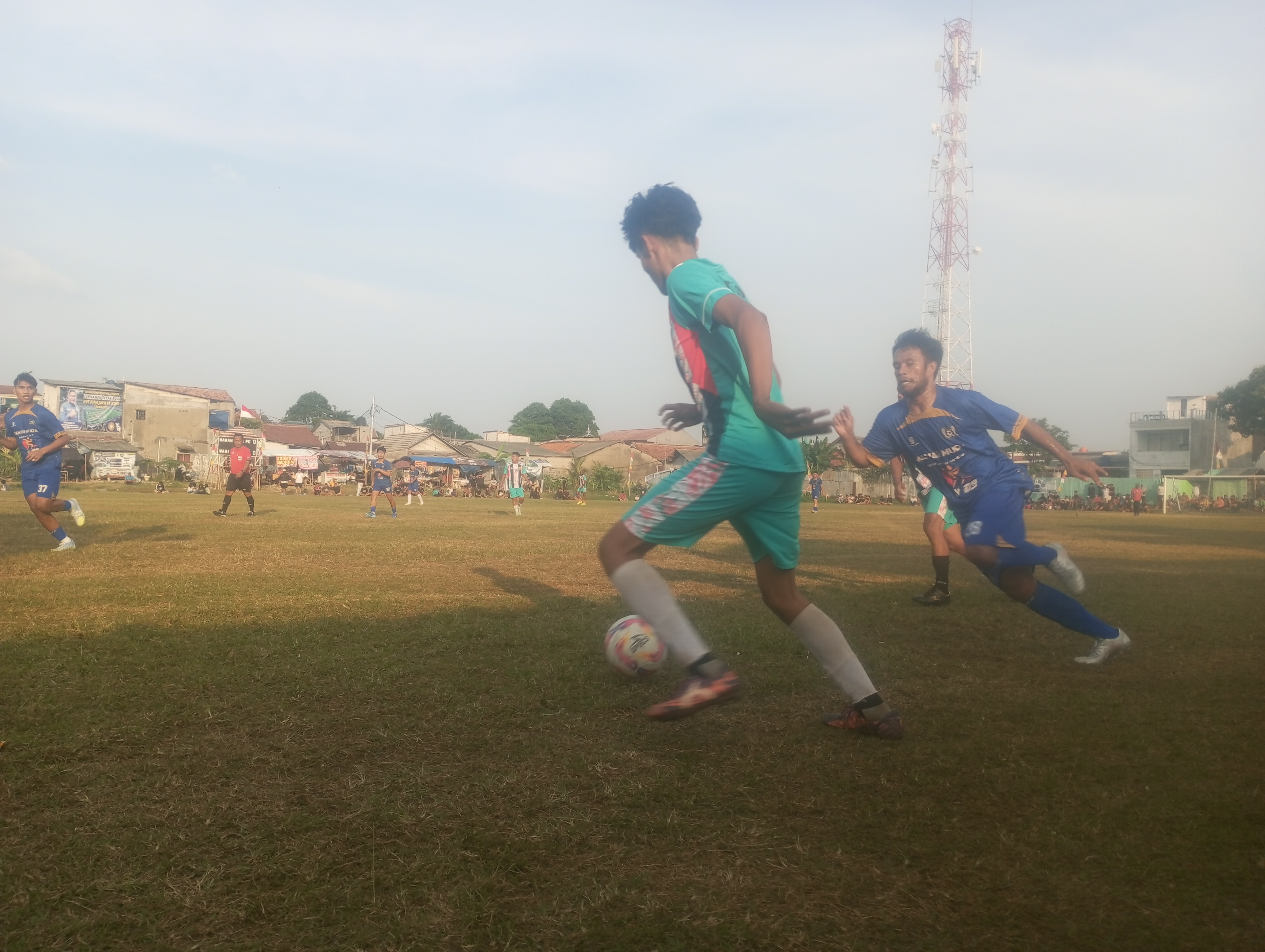 Penyerang Mamah Muda, Niko (biru) mencoba merebut bola dari kaki pemain Wani FC pada pertandingan, Selasa (16/06/2026).(tangselpos.id).
