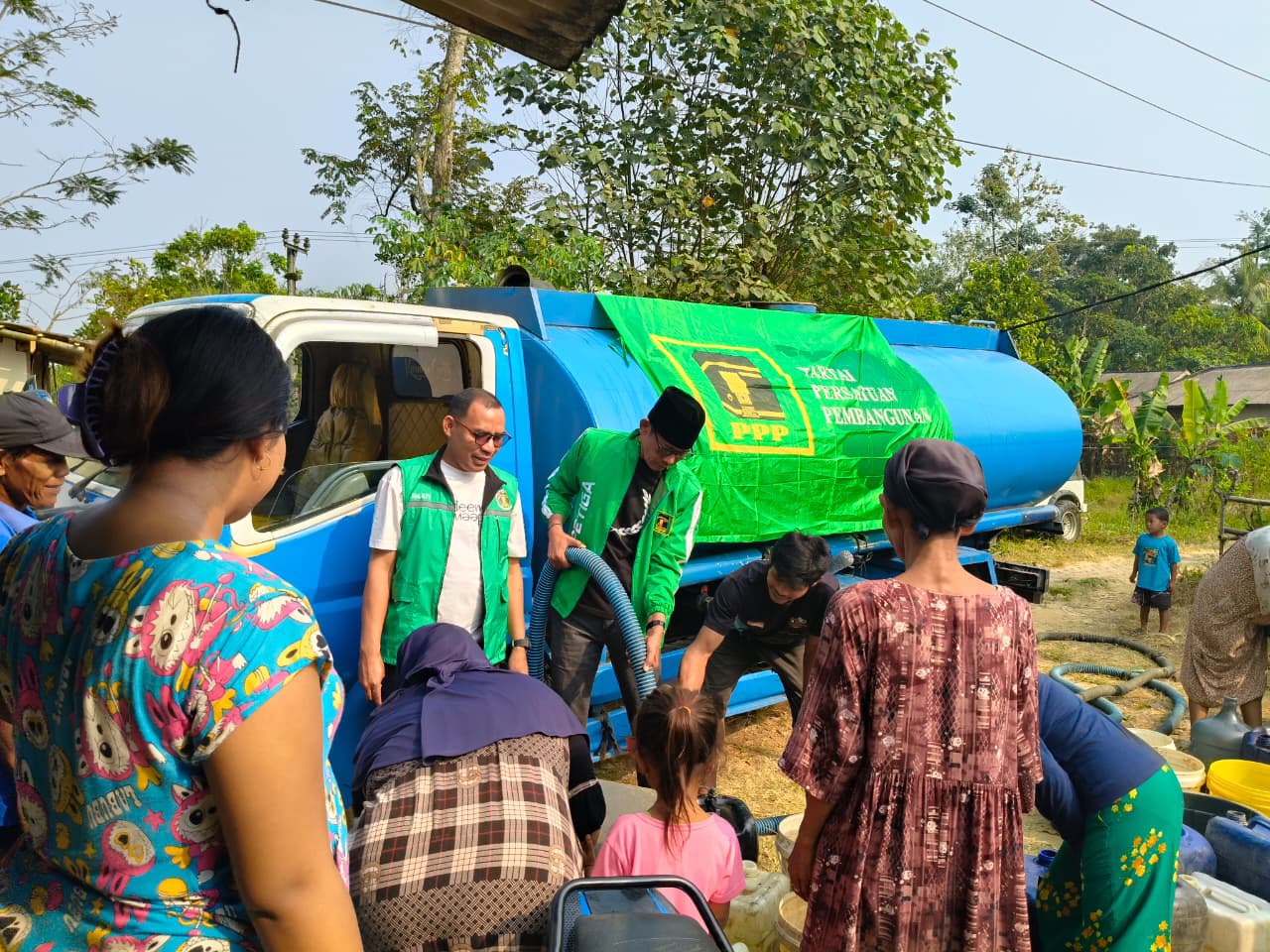 KUCURKAN BANTUAN AIR. Ketua DPC PPP Kabupaten Pandeglang, E. Supriadi, didampingi Sekretarisnya, sedang mengucurkan bantuan air bersih kepada warga terdampak kekeringan, di Kampung Babakan Ambon, Desa Babakan Keusik, Kecamatan Patia, Kabupaten Pandeglang, Jumat (31/7). (IST)
