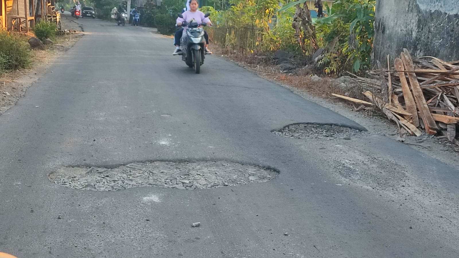 JALAN BOLONG. Pengguna jalan terlihat hati-hati saat melintas di Jalan Bama-Pagelaran di wilayah Kecamatan Pagelaran, Kabupaten Pandeglang, karena kondisinya ada yang rusak atau bolong, Kamis (16/7). (NIPAL SUTIANA/TANGSEL POS)