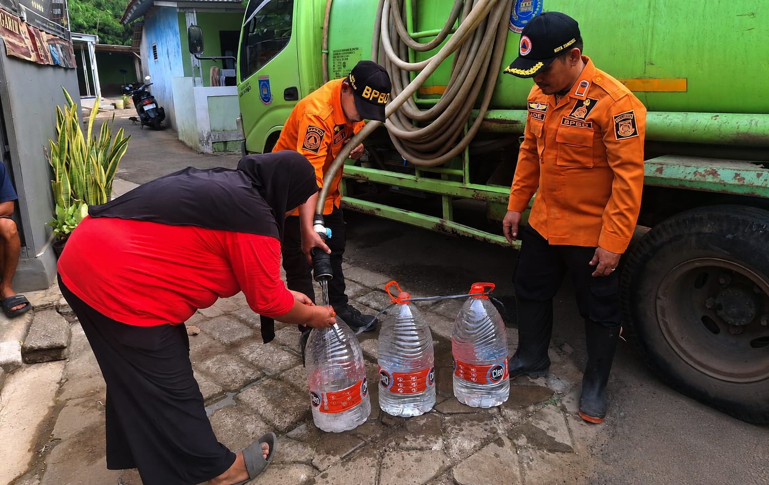 KEKERINGAN. Warga terdampak kekeringan di Keranggan saat mengambil air bersih yang disalurkan oleh BPBD Kota Tangsel.