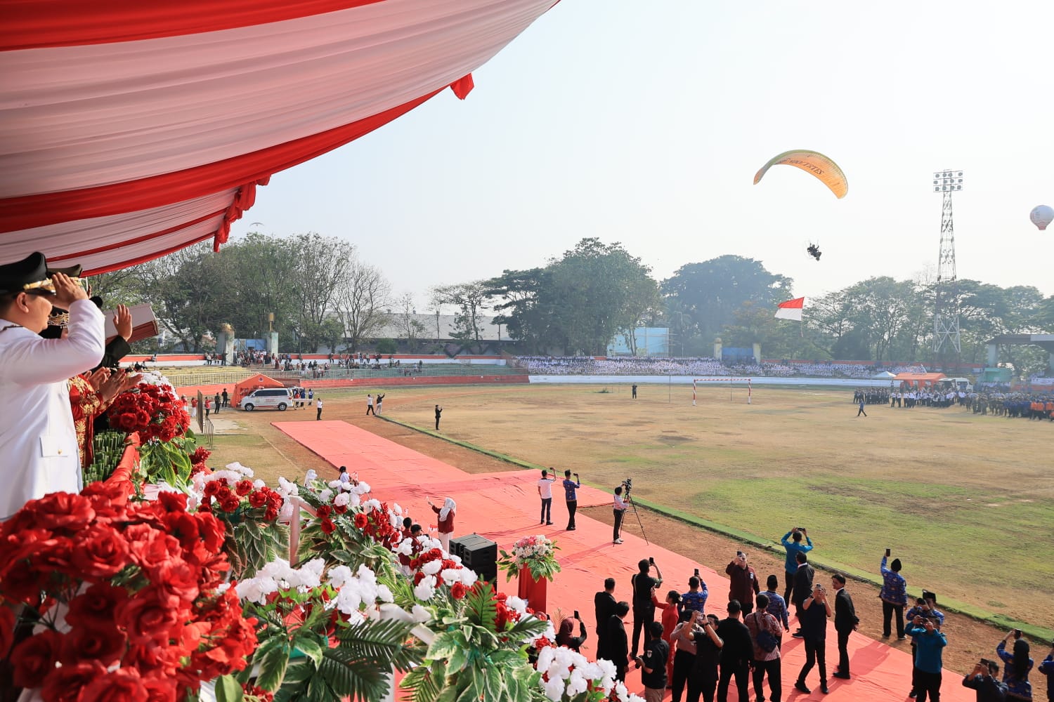 Walikota Serang, Budi Rustandi memberi hormat kepada atlet paramotor yang mengibarkan bendera Merah Puih dalam rangkaian peringatan HUT ke-81 RI di Stadion Maulana Yusuf, Senin (17/8/2026).(Istimewa)