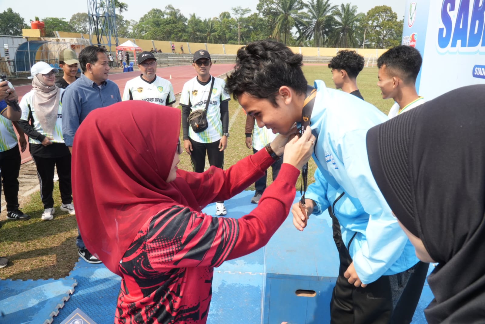 KALUNGKAN MEDALI. Bupati Pandeglang Raden Dewi Setiani, sedang mengalungkan medali kepada salah seorang atlet yang berhasil meraih juara SABP Cup V Tahun 2026, di Stadion Badak Kuranten, Kecamatan Majasari, Kabupaten Pandeglang, Sabtu (1/8). (DOK. PROKOPIM SETDA PANDEGLANG)