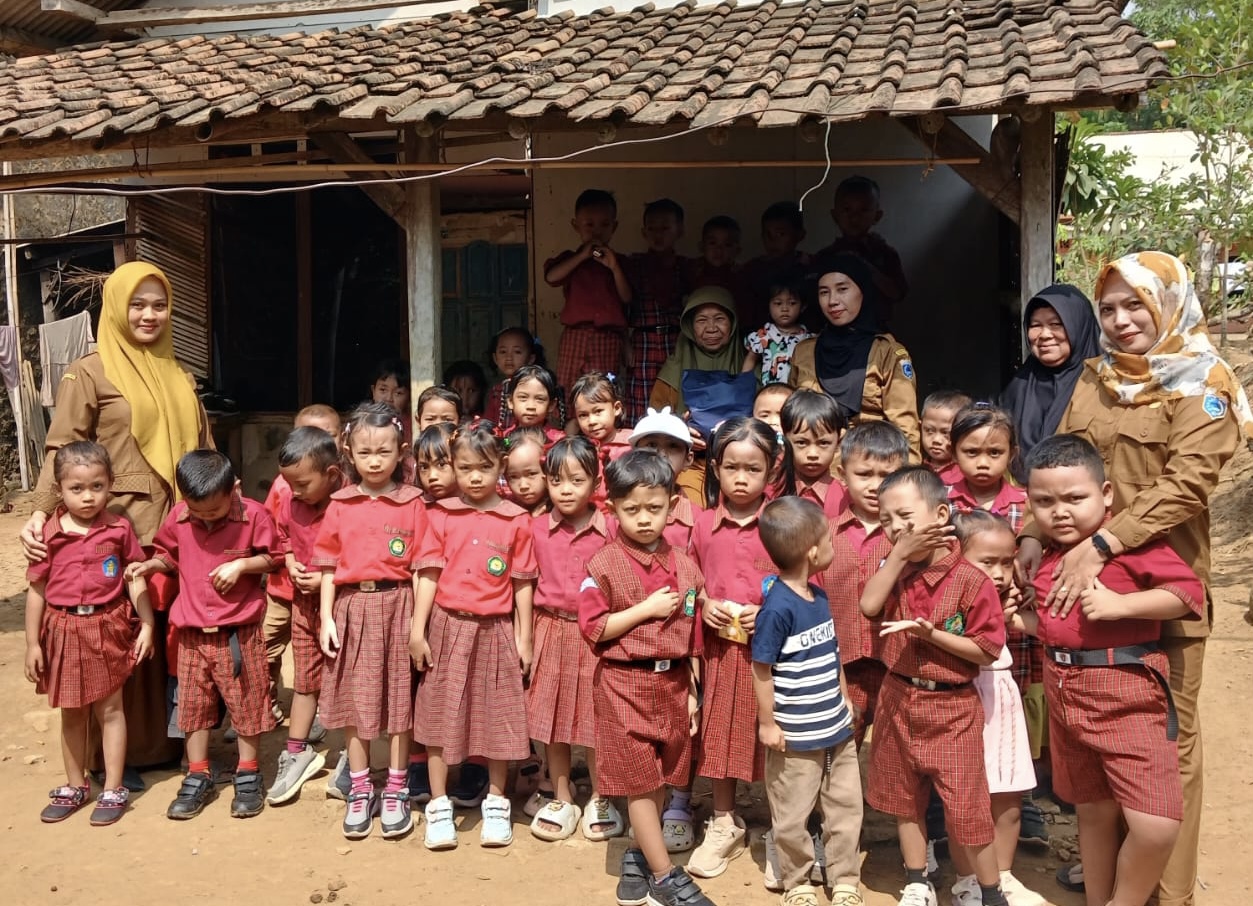 BERI BANTUAN. Dewan guru bareng anak-anak TK Assalam, sedang foto bersama dengan pemilik rumah yang berstatus janda lansia. Foto bersama itu dilakukan usai kegiatan memberikan bantuan, di wilayah Desa Desa Mendung, Kecamatan Cibaliung, Kabupaten Pandeglang, Senin (14/9). (ISTIMEWA)