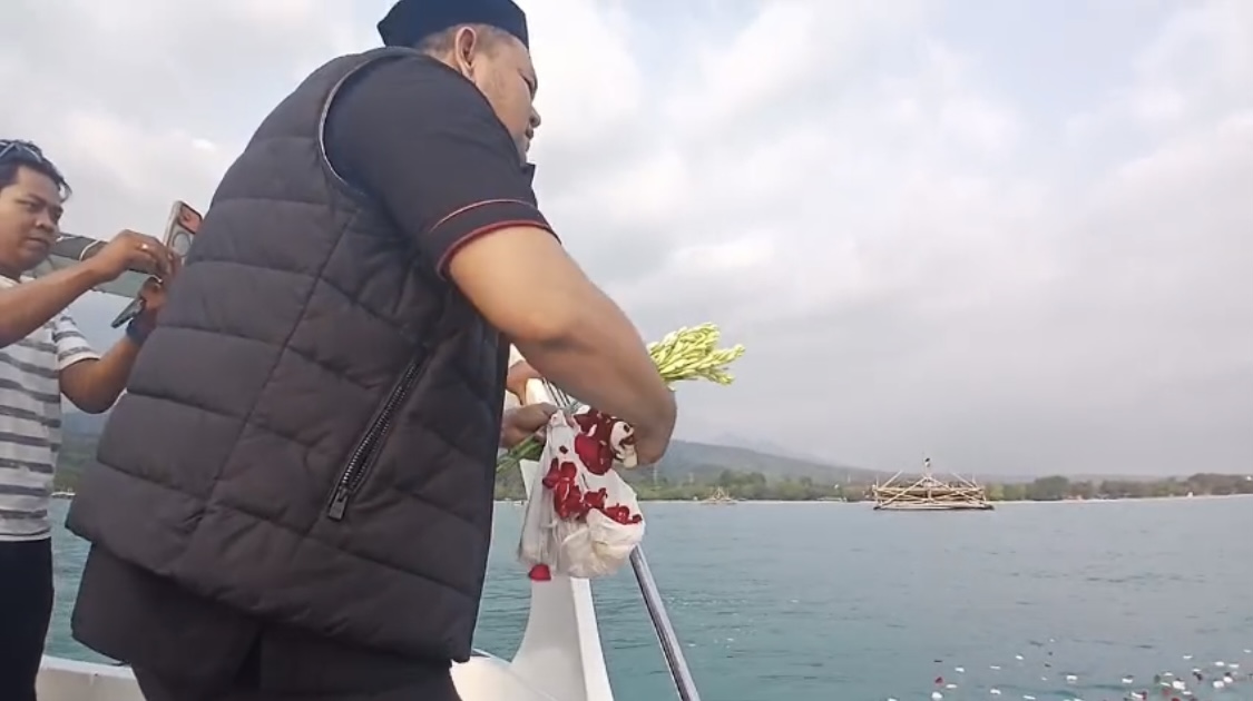 TABUR BUNGA. Anggota DPRD Lebak Fraksi PPP Regen Abdul Aris, sedang berdoa dan menaburkan bunga di perairan laut Carita, Kabupaten Pandeglang, Selasa (15/9). (ISTIMEWA)