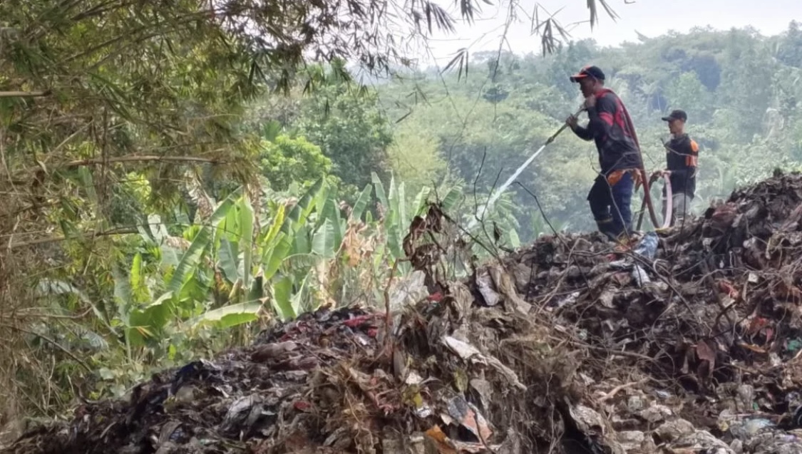 MEMADAMKAN BARA API. Para personel Damkar Kabupaten Pandeglang, sedang melakukan pemadaman bara api yang masih menyala di sekitar TPA di Desa Bojong Canar, Kecamatan Cikedal, Kabupaten Pandeglang, Rabu (2/9). (DOK. BPBDPK PANDEGLANG)