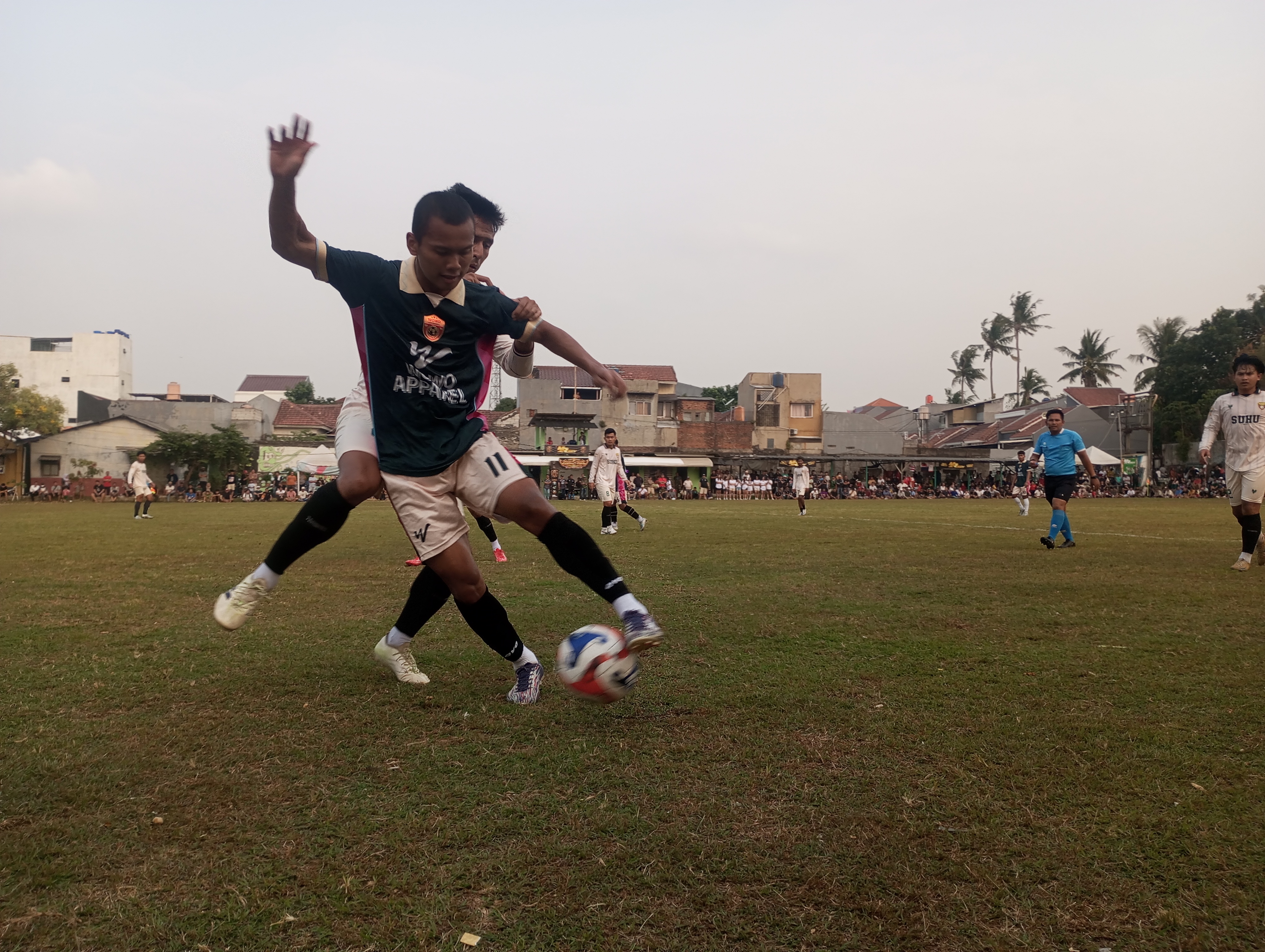 Penyerang Alebo Wowo FC, Wawan (depan) dikawal ketat pemain Suhu Shop FC pada Minggu (11/10/2026) sore.(red/tangselpos.id).