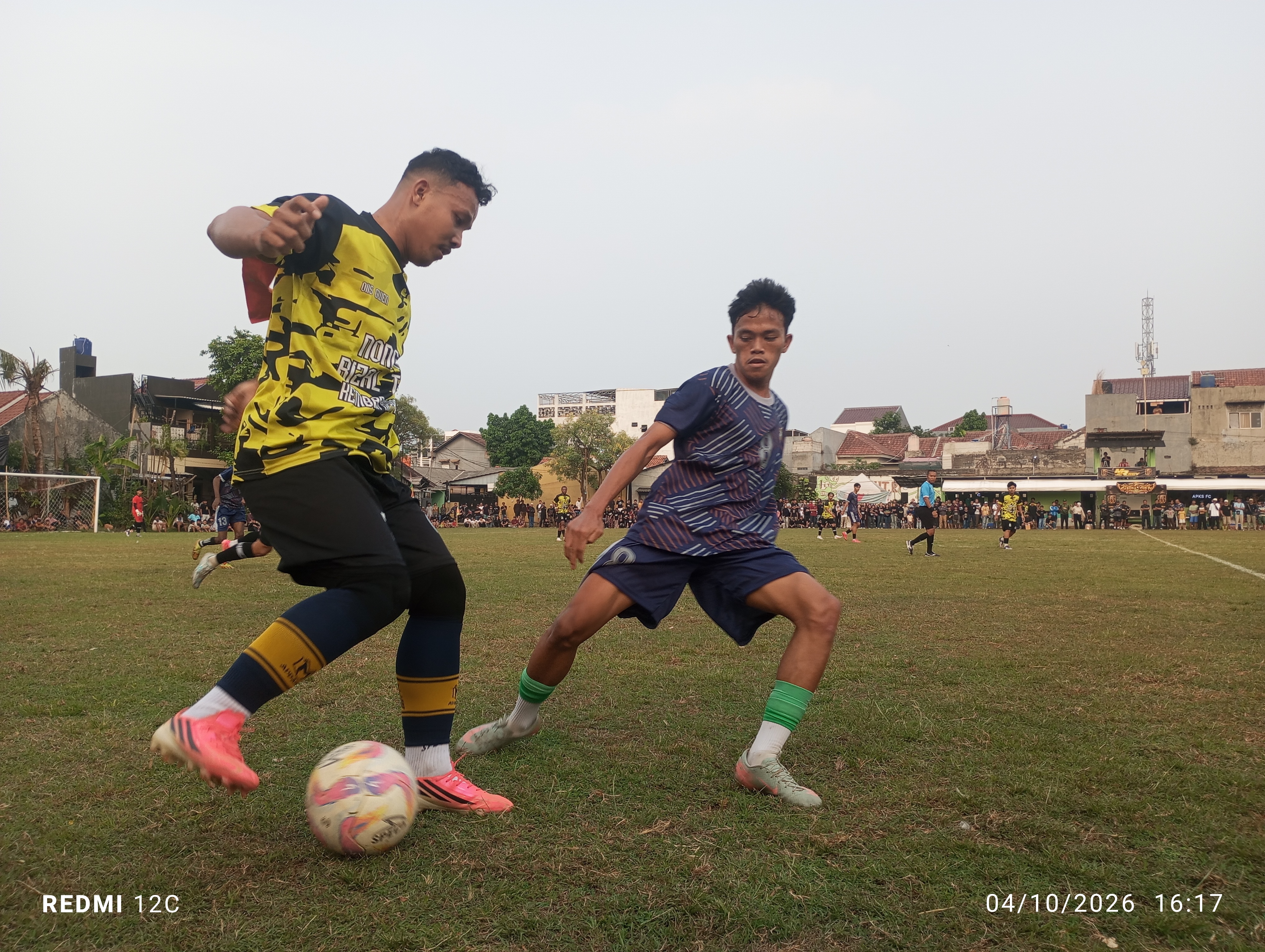 Kapten Damai Larangan FC, Andi Odang kuasai bola dibayangi pemain APKS FC, Jefri pada Minggu (04/10/2026) sore.(red/tangselpos.id).