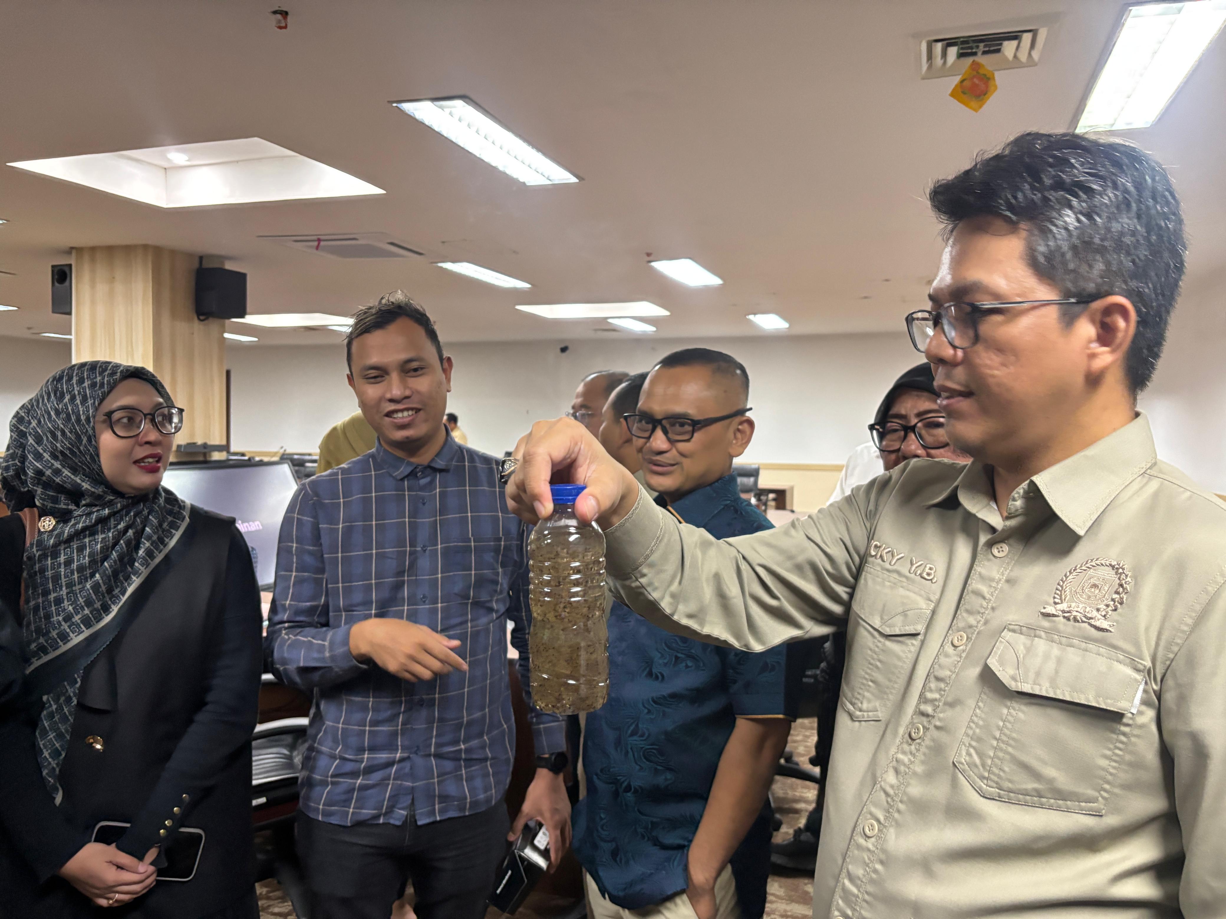 TERDAMPAK - Ketua Komisi II DPRD Kota Tangsel Ricky Yuanda (kanan) menunjukan kualitas air Perumahan Laoggon yang telah tercemar.