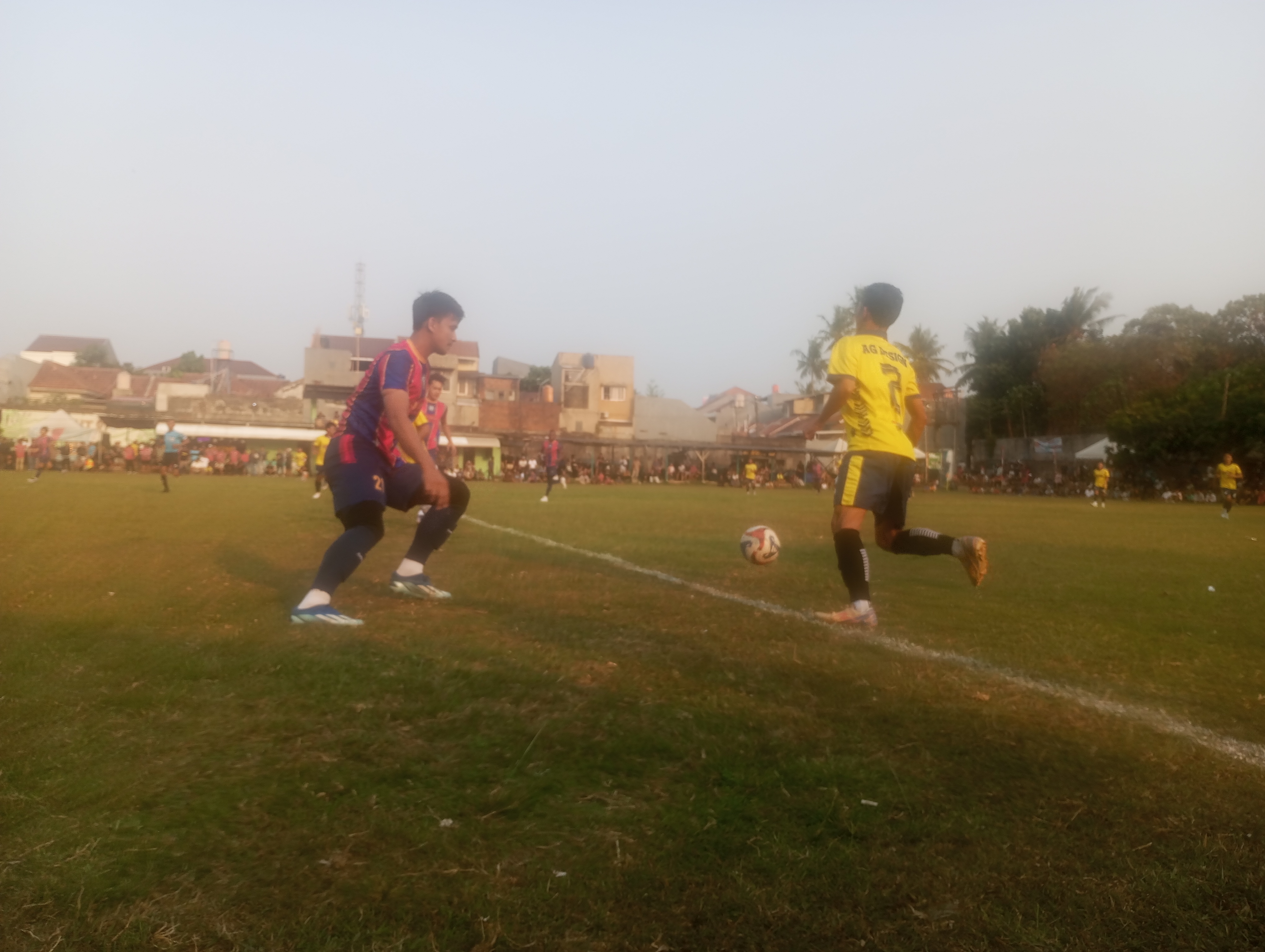 Bek Hoky FC, Wandi (kiri) mencoba menghadang pemain AG FC pada Kamis (08/10/2026) sore.(red/tangselpos.id).