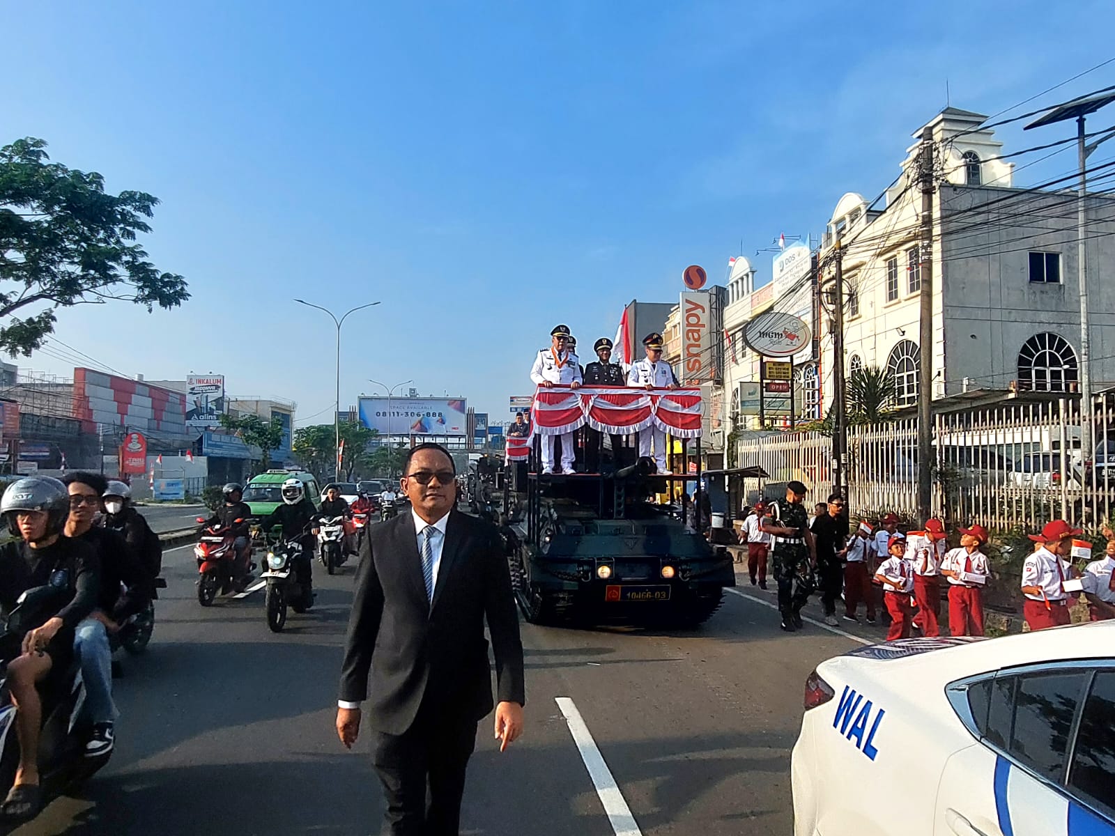 Menaiki tank tempur, Wali Kota dan Wakil Wali Kota Tangsel, Benyamin Davnie-Pilar Saga Ichsan disambut sorak sorai merdeka dari para siswa di sepanjang jalan menuju lapangan upacara. (tangselpos.id/rmn)