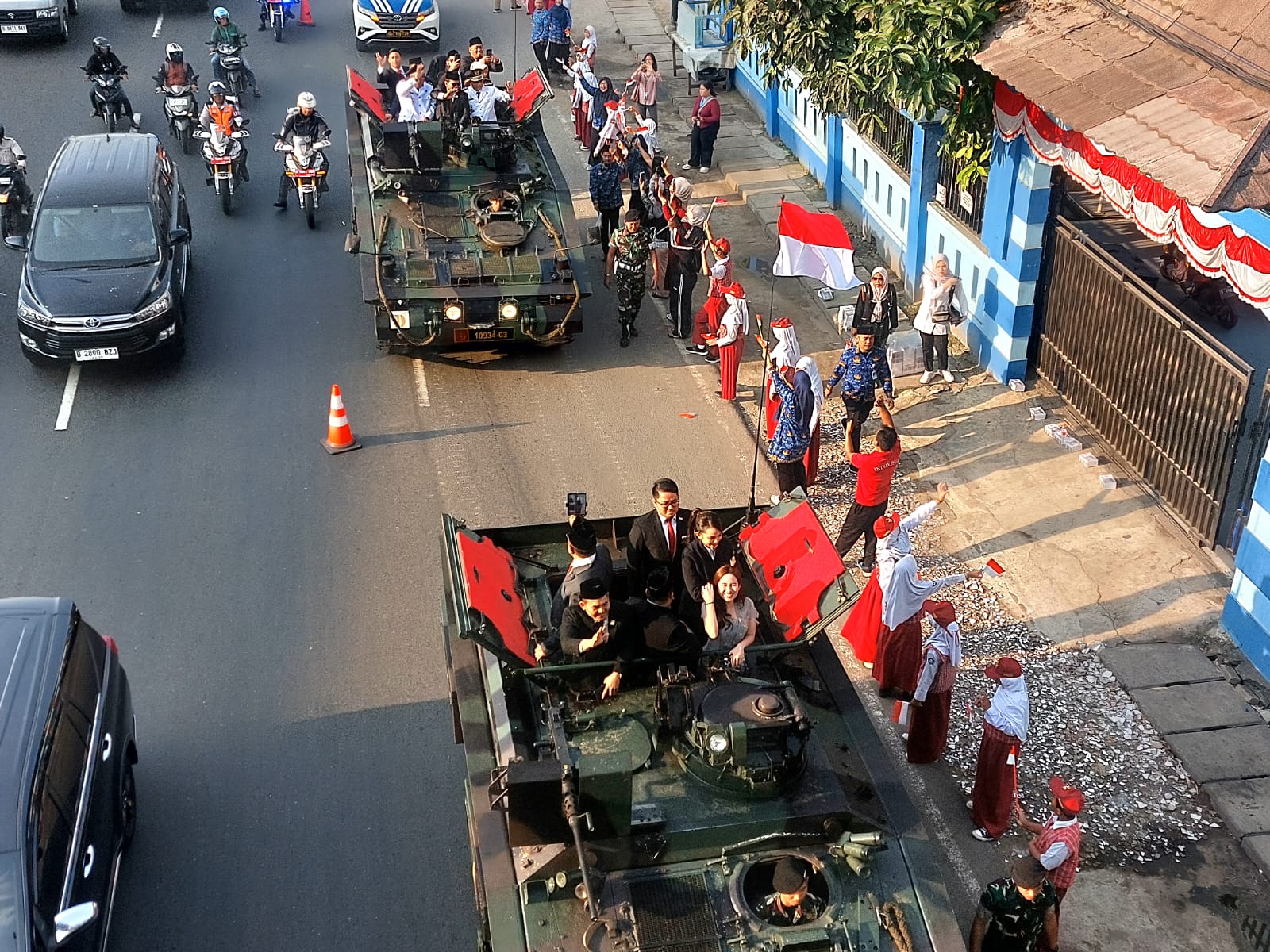 Menaiki tank tempur, Wali Kota dan Wakil Wali Kota Tangsel, Benyamin Davnie-Pilar Saga Ichsan disambut sorak sorai merdeka dari para siswa di sepanjang jalan menuju lapangan upacara. (tangselpos.id/rmn)