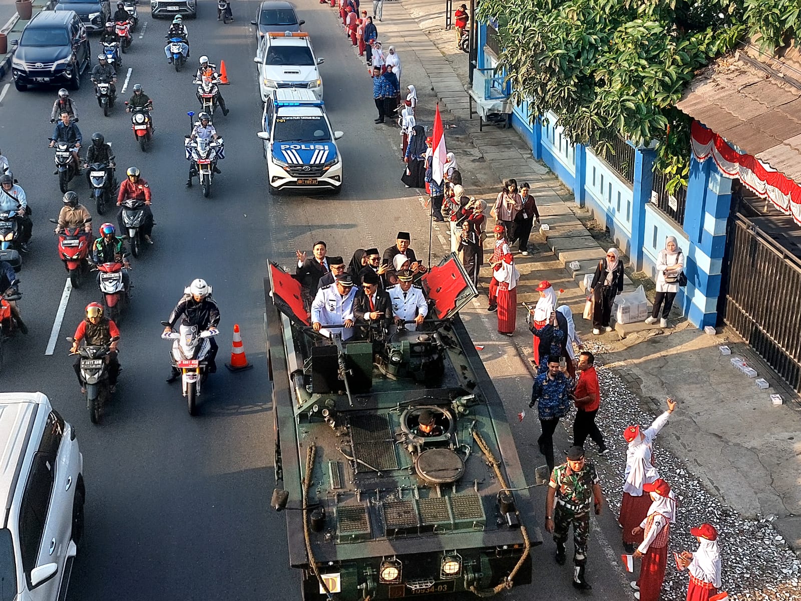 Menaiki tank tempur, Wali Kota dan Wakil Wali Kota Tangsel, Benyamin Davnie-Pilar Saga Ichsan disambut sorak sorai merdeka dari para siswa di sepanjang jalan menuju lapangan upacara. (tangselpos.id/rmn)