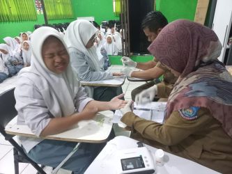 Petugas kesehatan Puskesmas Ciputat mengecek HB para siswa di sekolah yang dikunjungi.(mg.2)