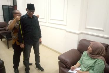 Anggota DPRD Pandeglang terpilih, E. Supriadi, tengah diukur untuk pembuatan jas.(Ari Supriadi-Tangsel Pos)