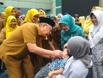 Wali Kota Tangsel, Benyamin Davnie saat memberi imunisasi polio kepada cucunya di rangkaian acara Peringatan Hari Anak dan Kick-off PIN Polio. (tangselpos.id/rmn)