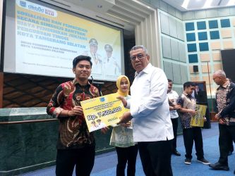 Wali Kota Tangsel, Benyamin Davnie saat menyalurkan bantuan biaya perkuliahan secara simbolis kepada mahasiswa yang tengah berjuang di akhir semester. Foto : Ist