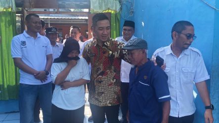 Bupati Lebak Moch. Hasbi Asyidiki Jayabaya sedang merangkul korban bencana sambil menenangkannya yang sedang menangis terharu telah dikunjungi Bupati, Rabu (12/3)