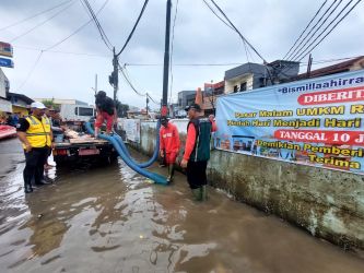 Petugas saat menggunakan pompa air guna menangani banjir di wilayah Pondok Aren, Selasa (4/3)