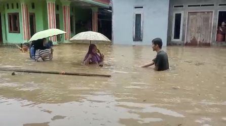 Warga Kampung Cikayas, Desa Cikayas, Kecamatan Angsana, sedang menerobos banjir untuk melakukan pengungsian ke wilayah yang tidak banjir, Senin (26/5).