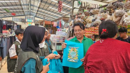 Kader Adiwiyata SDN Pondok Jagung 02 saat bagi-bagi tas jinjing ke pengunjung pasar di wilayah Serpong Utara, Senin (5/5)